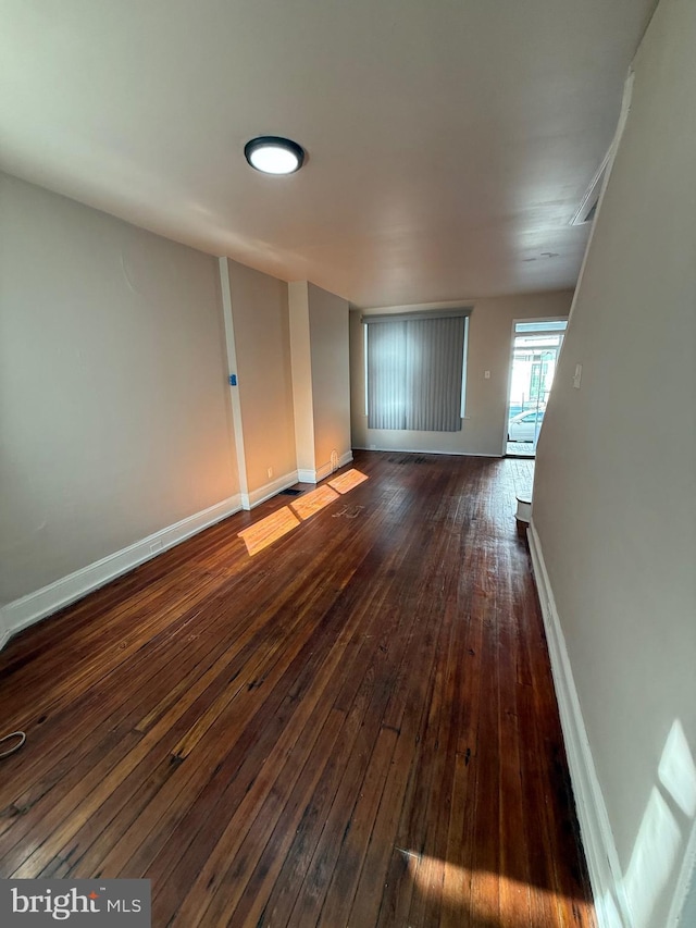 unfurnished room with dark wood-type flooring