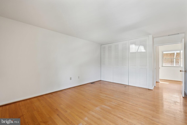 unfurnished bedroom featuring a closet and light wood-style flooring