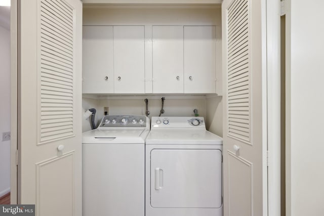 clothes washing area featuring independent washer and dryer and cabinet space