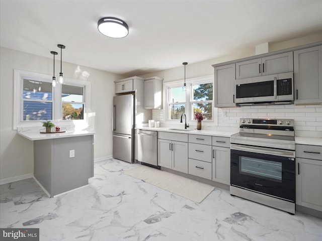 kitchen with gray cabinetry, sink, pendant lighting, and appliances with stainless steel finishes