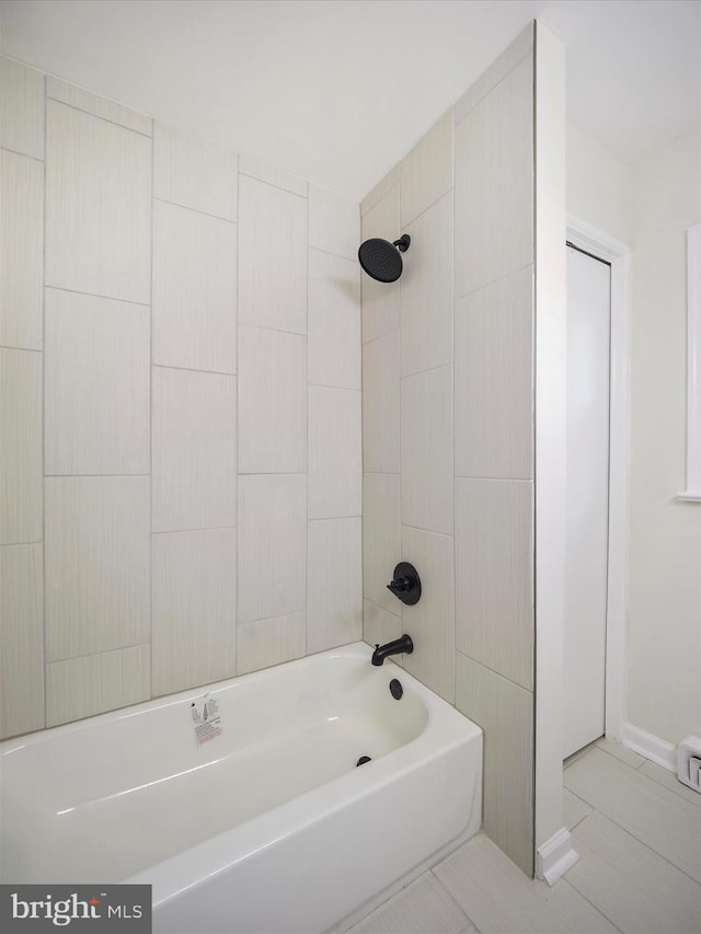 bathroom with tiled shower / bath combo and tile patterned floors