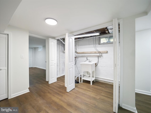 basement with sink and dark wood-type flooring