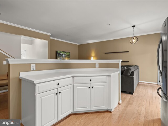 kitchen featuring ornamental molding, decorative light fixtures, light hardwood / wood-style flooring, white cabinetry, and stainless steel refrigerator