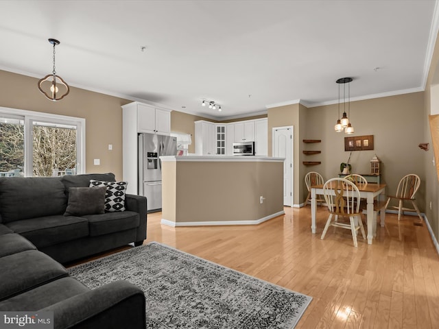 living room featuring rail lighting, crown molding, and light hardwood / wood-style flooring