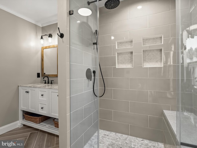 bathroom with tiled shower, vanity, and crown molding