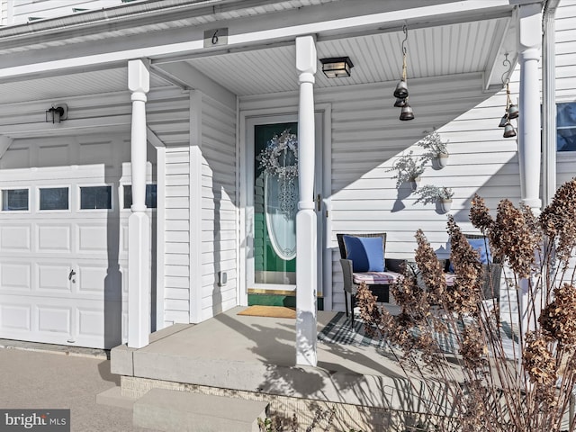 entrance to property with covered porch and a garage