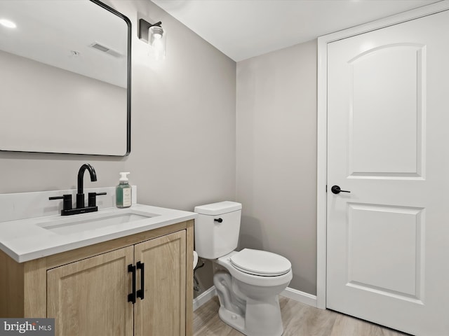 bathroom with vanity, hardwood / wood-style flooring, and toilet