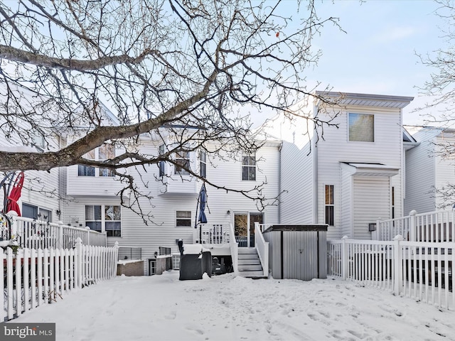 snow covered house with a wooden deck