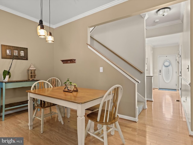 dining area with light hardwood / wood-style flooring and ornamental molding