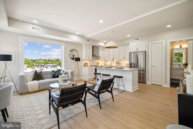 living room with light hardwood / wood-style flooring and a healthy amount of sunlight