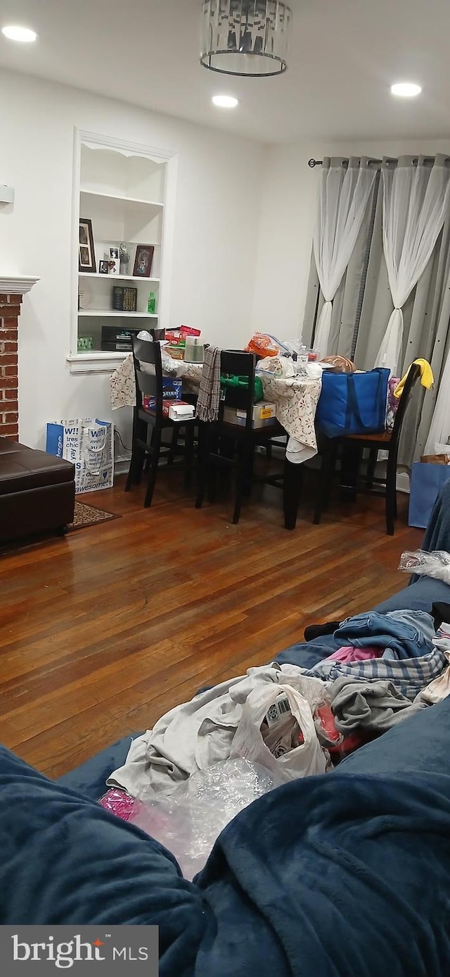 dining space with dark wood-type flooring and built in shelves