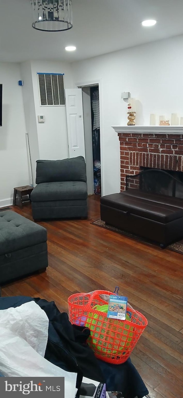 living room with dark hardwood / wood-style floors and a brick fireplace