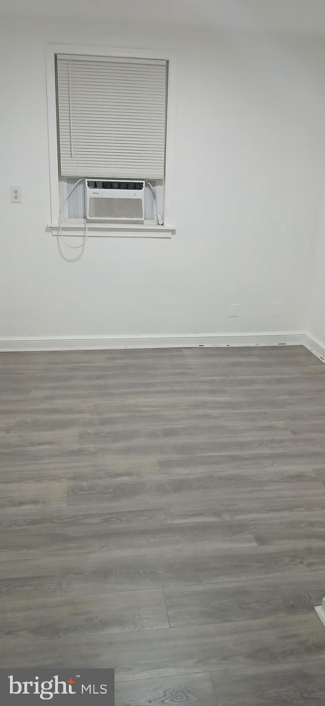 empty room with cooling unit and wood-type flooring