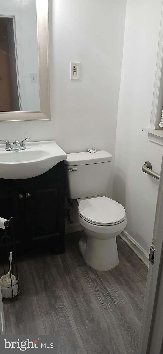 bathroom featuring vanity, hardwood / wood-style floors, and toilet