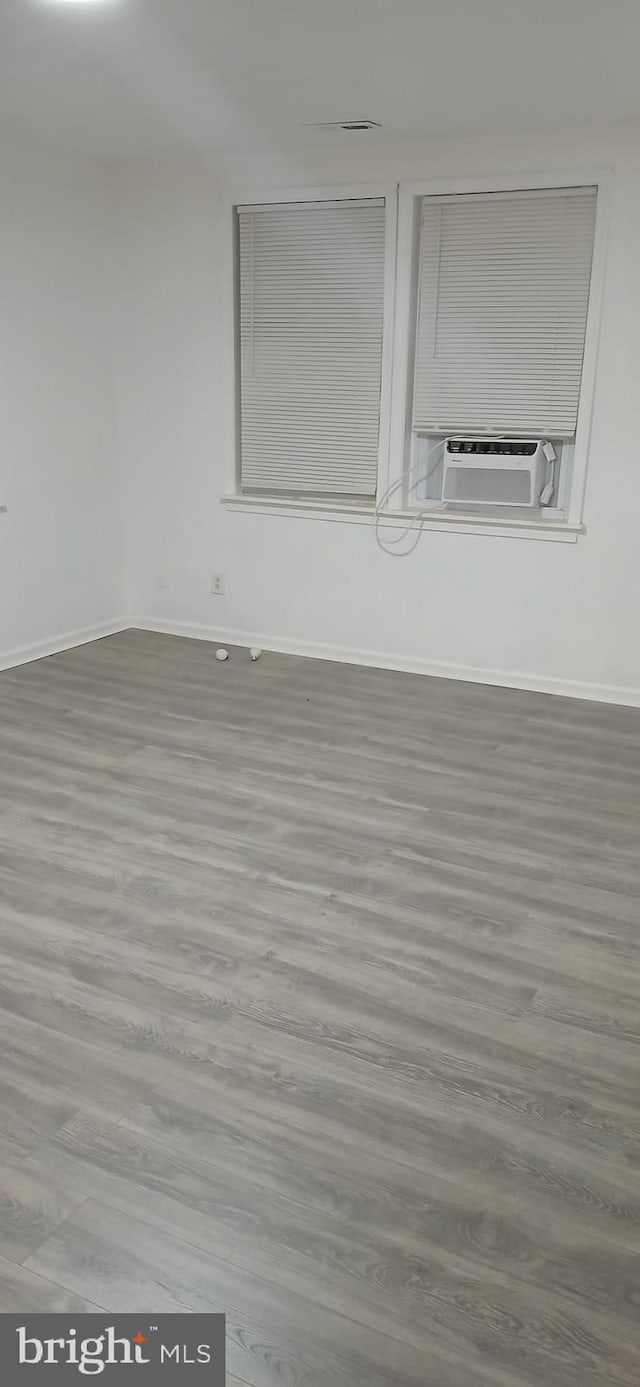 unfurnished room with cooling unit and wood-type flooring