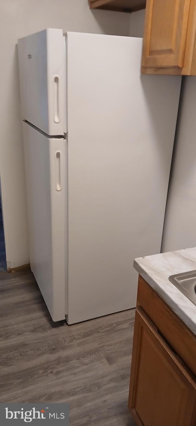 kitchen with hardwood / wood-style flooring and white fridge