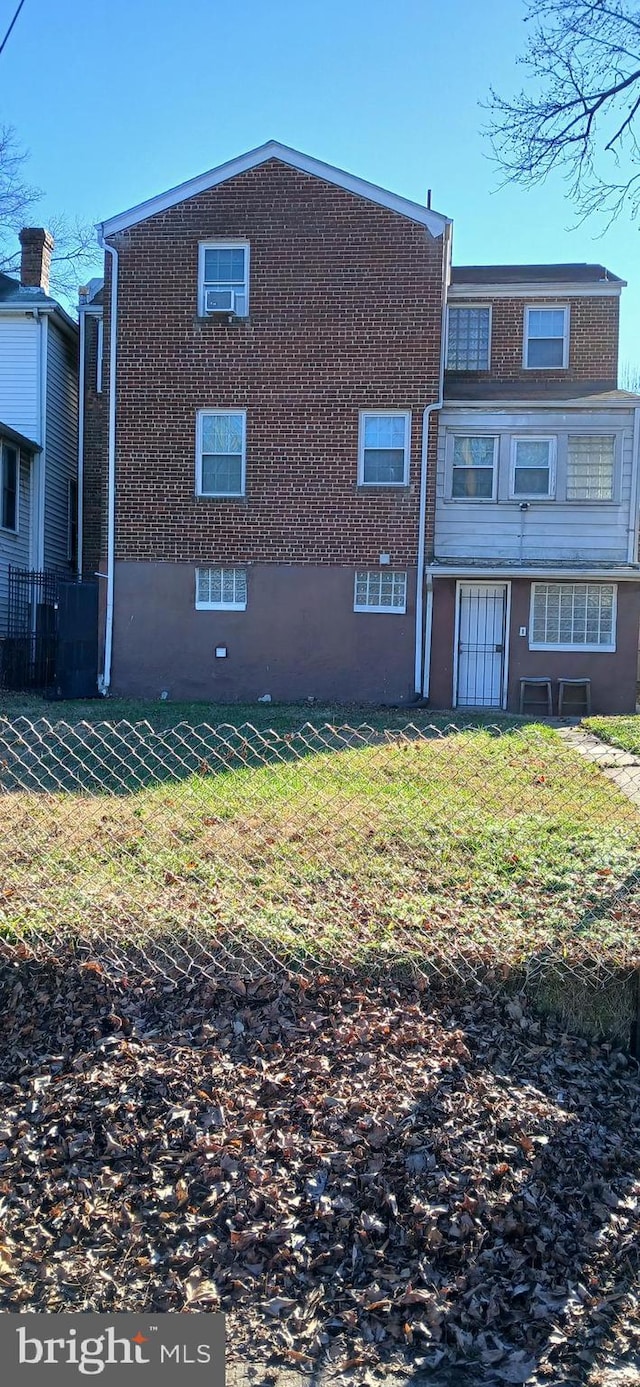 rear view of property with a lawn