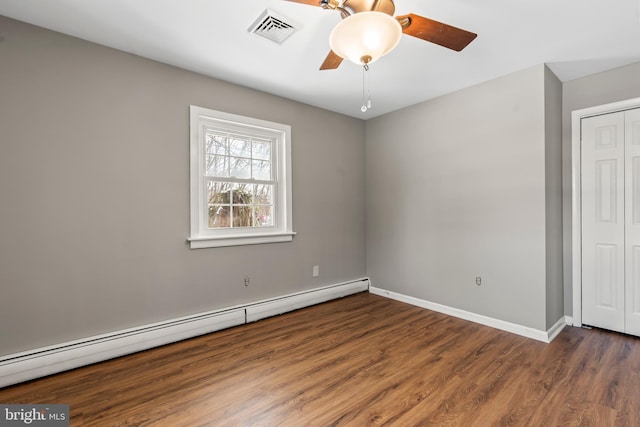 empty room with visible vents, a baseboard heating unit, a ceiling fan, wood finished floors, and baseboards