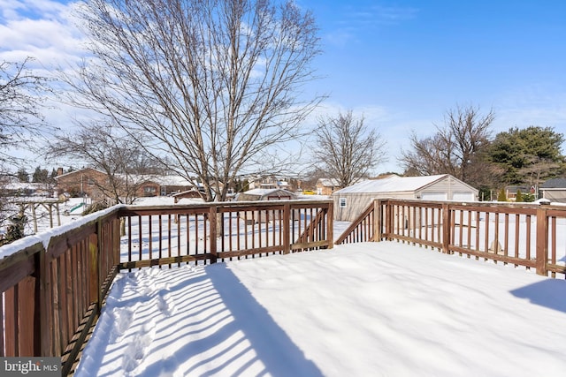 snow covered deck with an outdoor structure and a residential view