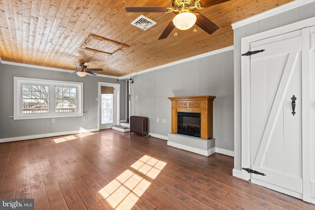 unfurnished living room featuring radiator, crown molding, dark hardwood / wood-style floors, wooden ceiling, and wood walls