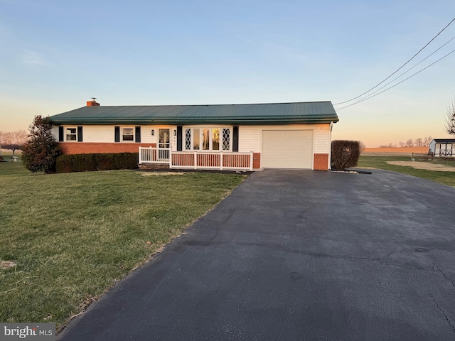 ranch-style house with a porch, a garage, and a lawn