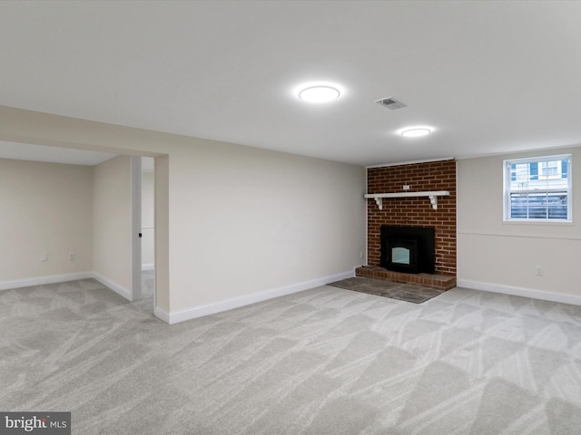 unfurnished living room with light colored carpet and a brick fireplace