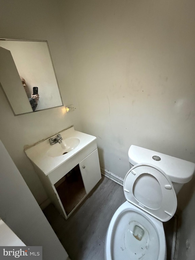 bathroom with wood-type flooring, toilet, and vanity