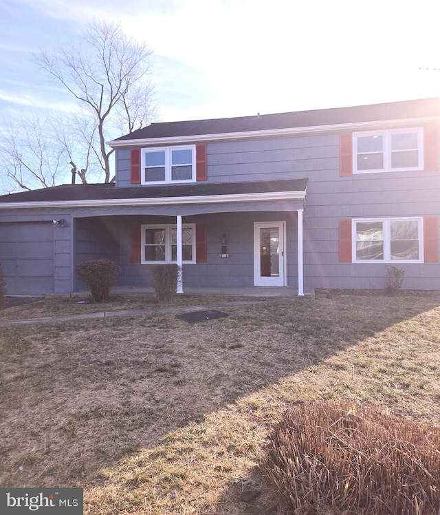 view of front of property with a front yard and a garage