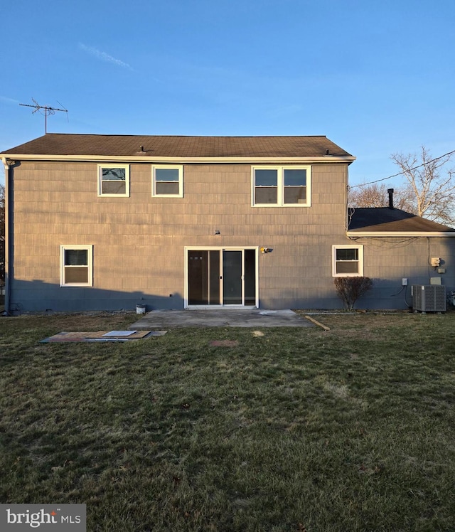 rear view of property with central AC unit, a yard, and a patio