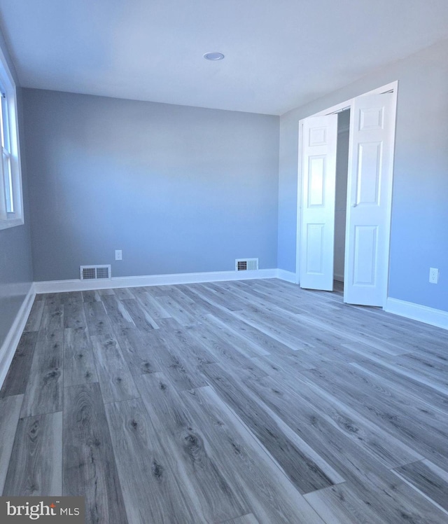 unfurnished bedroom with a closet and wood-type flooring