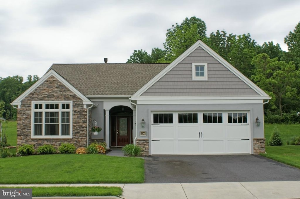 craftsman inspired home featuring a garage and a front yard