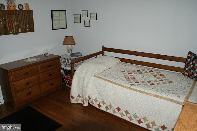 bedroom with dark wood-type flooring