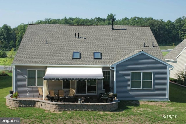 back of house with a patio and a lawn