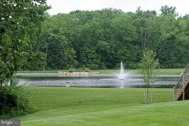 view of home's community featuring a lawn and a water view