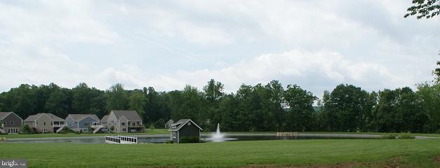 surrounding community featuring a water view and a lawn