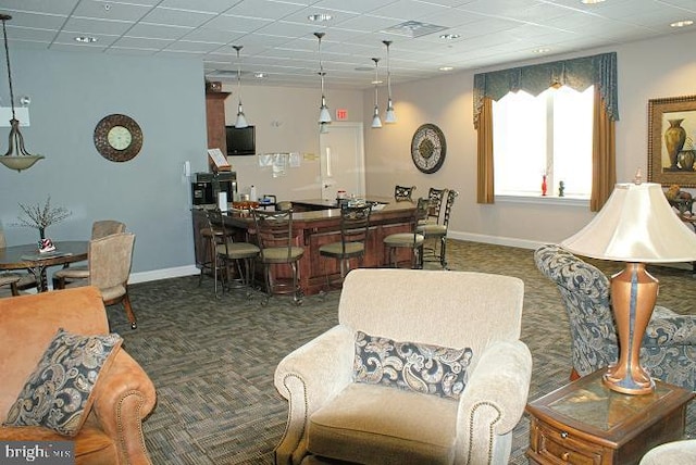 living room with bar area and dark carpet