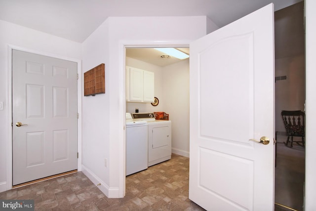 clothes washing area with cabinets and washer and clothes dryer