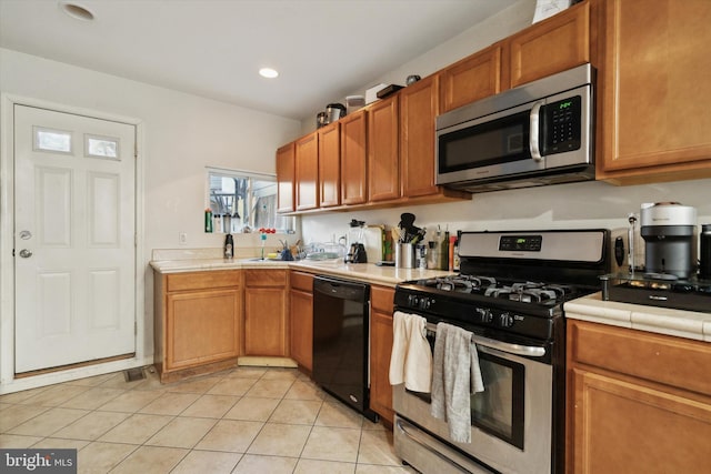 kitchen with light tile patterned floors and stainless steel appliances