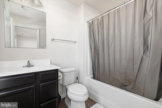 full bathroom featuring hardwood / wood-style flooring, vanity, shower / tub combo, and toilet