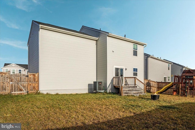 rear view of property featuring a yard and a playground