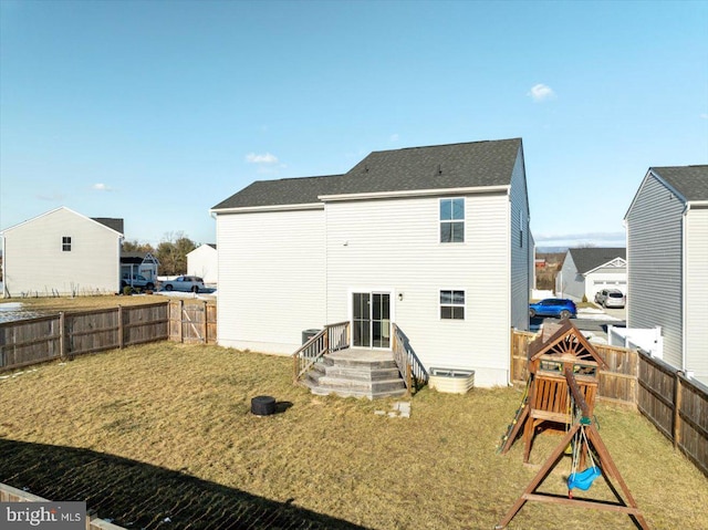 rear view of property featuring a playground and a lawn