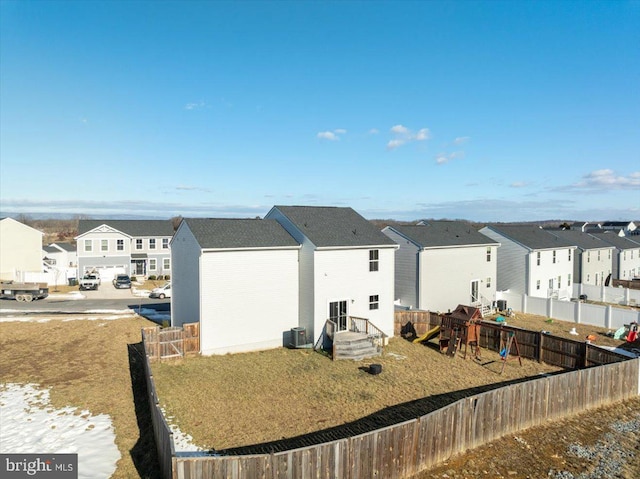 back of house featuring central AC and a playground