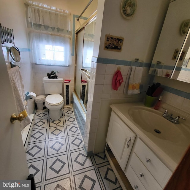 bathroom with vanity, tile walls, and toilet