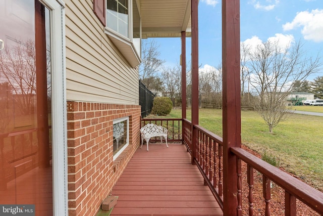 wooden terrace featuring a yard and a porch