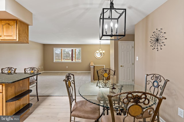 dining space featuring light wood-type flooring and a chandelier