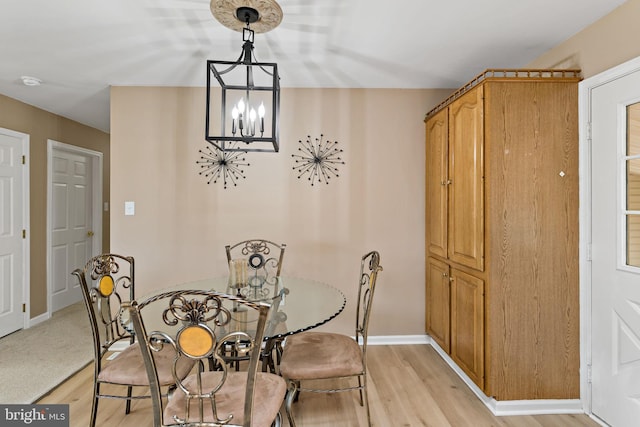 dining space featuring an inviting chandelier and light hardwood / wood-style flooring