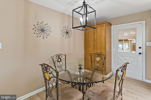 dining area with a notable chandelier and light wood-type flooring