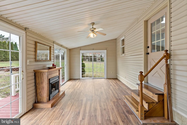 unfurnished sunroom with ceiling fan, wood ceiling, and vaulted ceiling