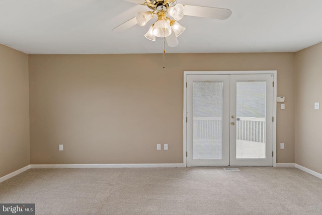 spare room with ceiling fan, french doors, and light colored carpet