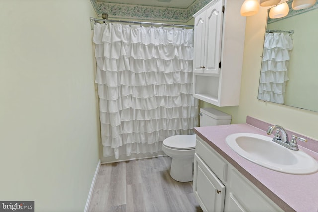 bathroom with curtained shower, toilet, vanity, and hardwood / wood-style flooring